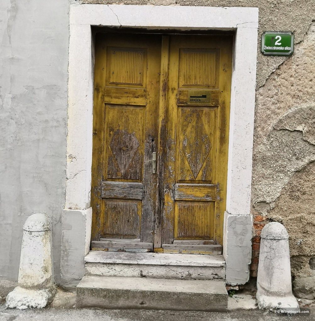 Rustic, small, yellow, wooden door in Ljubljana, Slovenia