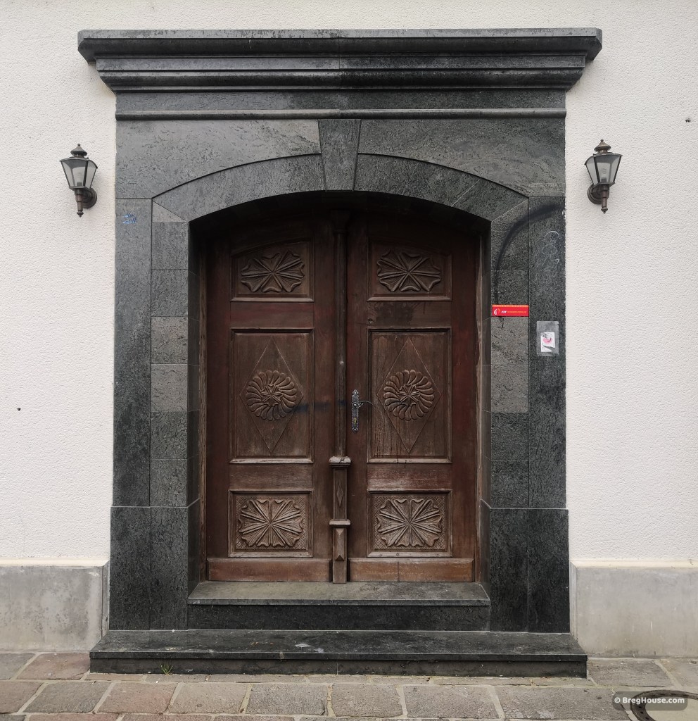 Wooden door with black granite surround in Ljubljana, Slovenia