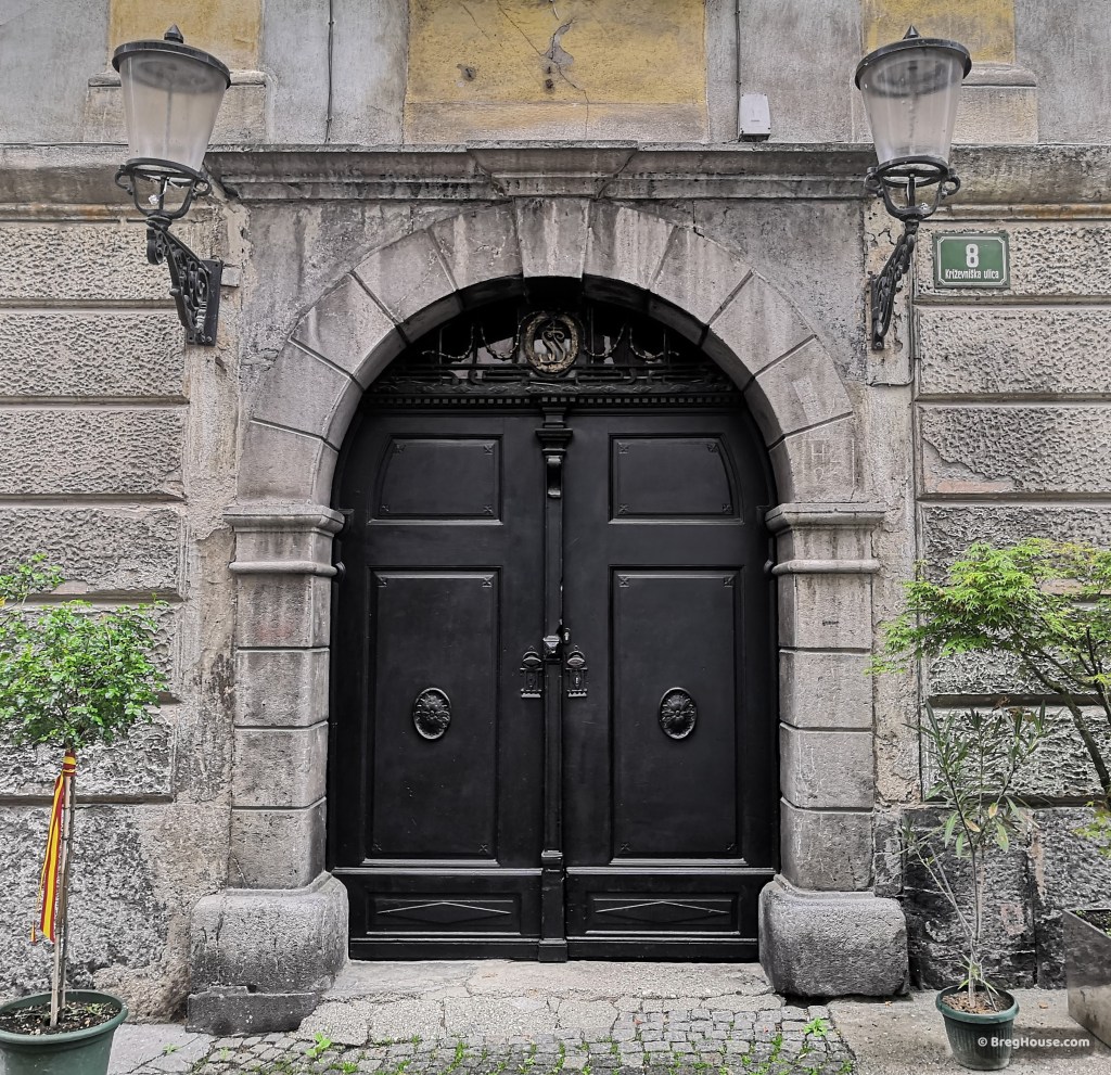 Black, arched, wooden door in Ljubljana, Slovenia