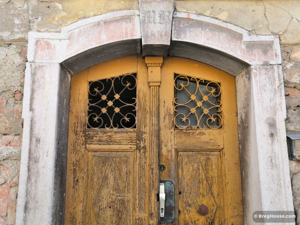 Very old wooden, painted yellow door in Ljubljana, Slovenia